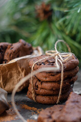 cookies with pieces of chocolate tied with a string on the background of fir branches. Christmas cookies