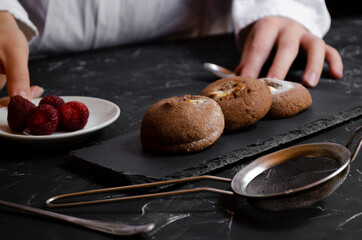 chocolate chip cookies on a table with strawberries and icing sugar