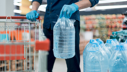 man in protective gloves with a bottle of drinking water.