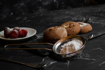 chocolate chip cookies on a table with strawberries and icing sugar