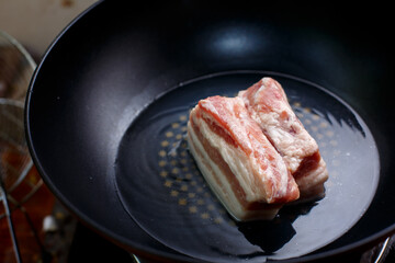 Boiling streaky pork in a frying pan to make crispy pork