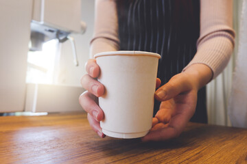 Close up image of a barista serve take away coffee in a coffee shop.