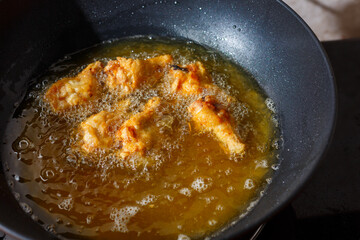 Close up fried chicken wings in boiling oil