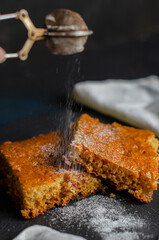 Fototapeta premium cake on the table sprinkled with powdered sugar