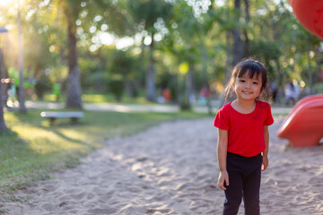 Asian child playing with sand in the playground