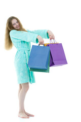 Cheerful girl in a short robe waving multicolored paper bags.
