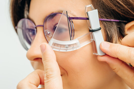 ophthalmologist measures rim of glasses with special tool