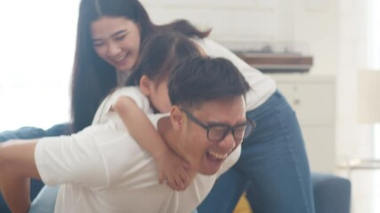 Happy cheerful Asian family dad, mom and daughter having fun playing congratulations with birthday at at house. Self-isolation, stay at home, social distancing, quarantine for coronavirus prevention. - Powered by Adobe