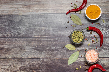Assortment of spices and herbs on wooden rustic table with copy space for your design.