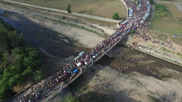 Long line of people crossing Massacre or Dajabon river. Aerial