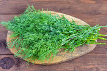 A large bunch of fresh organic dill on a rustic wooden background.