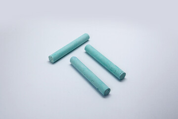 Colored chalk, in the form of small elongated cylinders in a wide variety of colors, used as school supplies for writing or drawing on a blackboard.