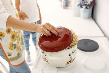 Cute little son with mother. Family at home in a kitchen. People make pasta.