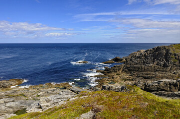 Fototapeta na wymiar Vue panoramique sur l'horizon, les rochers et la mer bleue indigo depuis la côte verdoyante du nord de l'Irlande.