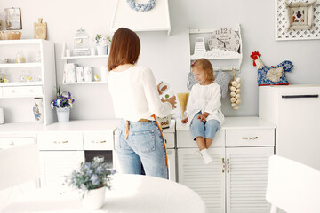 Cute little son with mother. Family at home in a kitchen.