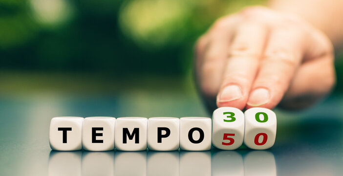 Hand turns dice and changes the expression "tempo 50" ("speed limit 50") to "tempo 30" ("speed limit 30").