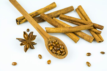 Anise seeds in a spoon, anise and cinnamon isolated on a white background.