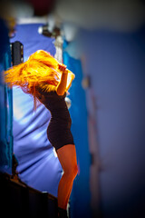 dancer performs during a rock music concert, blurred background.