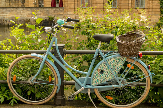 old blue bicycle with basket at the roadside