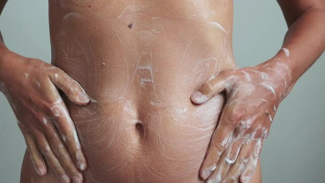 Beautiful young woman taking a shower and washing his body with soap