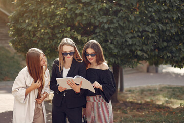 Students in a park. Girl in a park. Friends with a notebooks.