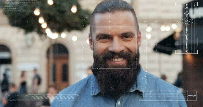 Portrait of young handsome Caucasian guy with beard at street with face recognition technology on. Biometric facial recognition. Close up of male smiling to camera in city outdoor. 3D scanning.