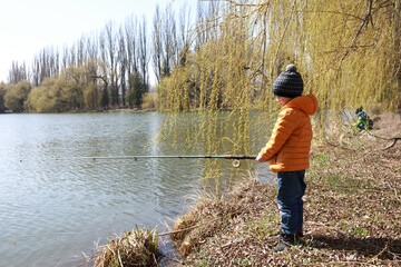 Fototapeta na wymiar Child fishing on lake in spring