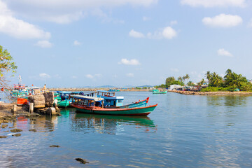 Fototapeta na wymiar Vietnamese junk fishing boats on river. Old wooden boat moored near shore