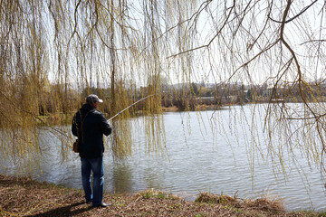 Man fishing on lake in spring