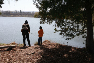Fototapeta na wymiar Mother with son fishing on lake