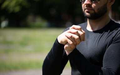 Man doing arm stretching exercises to warm up his muscles before starting a workout.