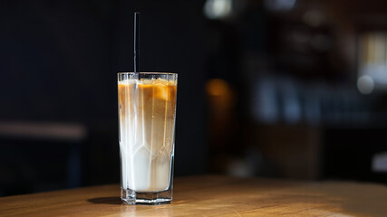 Coffee drink in a glass cup. Latte on a dark background in a cafe. Business stock photo for design