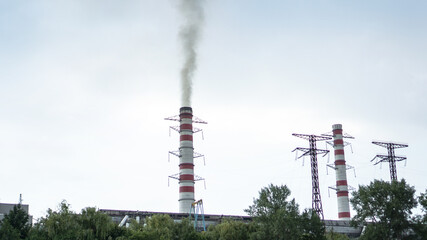 Obraz premium Pipe of the plant with which there is smoke against the sky. Factory and environmental topics of environmental pollution. Stock background for design.