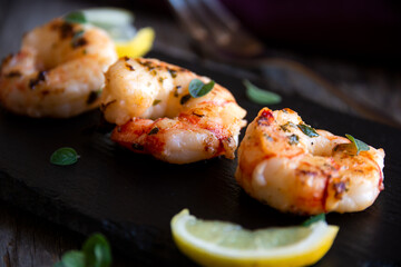 Roasted shrimps with lemon and herbs, healthy seafood meal