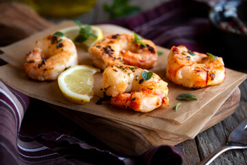 Roasted shrimps with lemon and herbs, healthy seafood meal