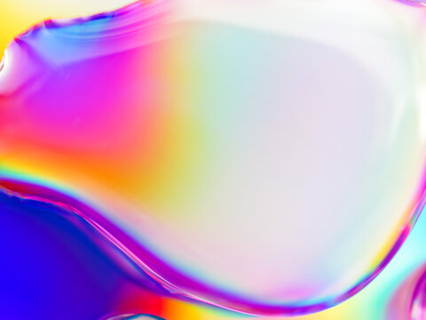 Abstract composition. Drops of liquid are on an iridescent surface. Slightly defocused image. Trending background of saturated colors and gradients.