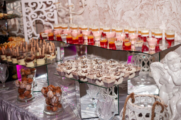 Sweet cakes in cups at a wedding buffet. Candy bar catering