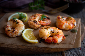 Roasted shrimps with lemon and herbs, healthy seafood meal