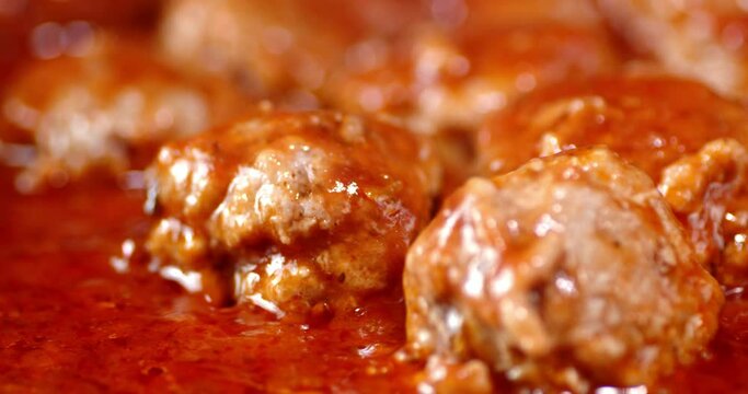 Cooking meatballs in tomato sauce. A slow rotation.