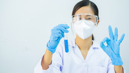 Fototapeta na wymiar Medical or scientific researcher or man doctor looking at a test tube of clear solution in a laboratory