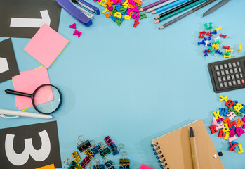 Office supplies on a blue background. Copy of space. A place for illustrations. Notepad, pen, calculator, stapler, buttons and magnifier.