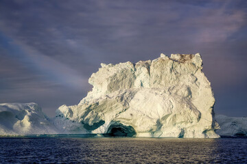 Fototapeta na wymiar huge floating glaciers in the sea illuminated by the sun's rays