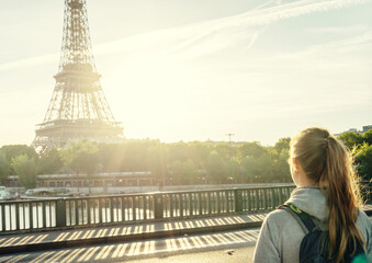 woman tourist walking  in front of the Eiffel Tower in Paris, France