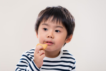 Asian kid boy eat cookie on white background