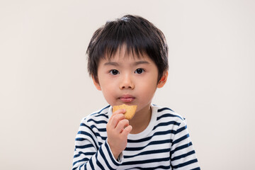 Kid boy eat cookie on white background