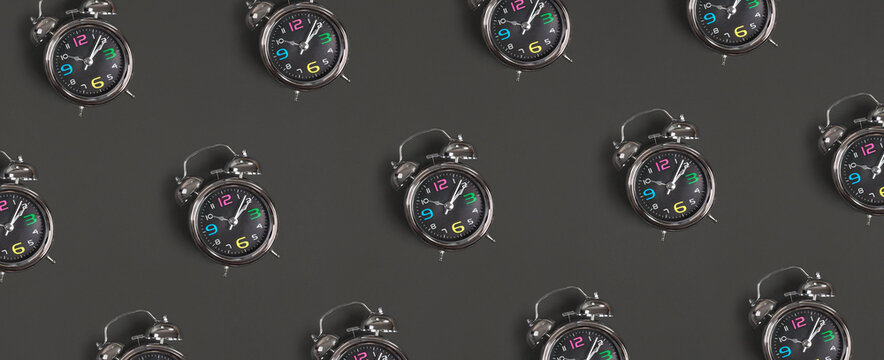 Pattern of metal antique alarm clock on black background. Back to school concept. Flat lay, Top view.