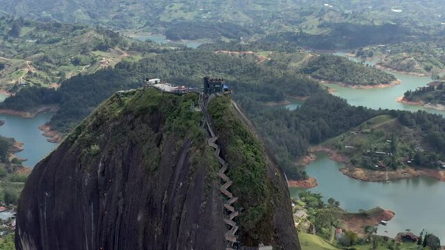 El Peñón de Guatapé in Colombia aerial drone video. Orbiting shot over famous Piedra del Peñol staircase with 649 steps leading to an amazing view over Guatapé lakes and islands.