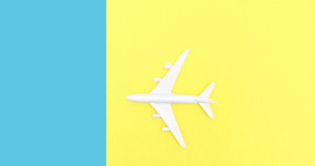 toy airplane on a double yellow-blue background. Summer vacation concept, travel.