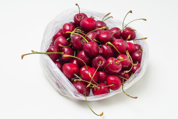 cherries in a transparent bag on a white table
