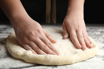 Obraz na płótnie Canvas Woman kneading dough for pizza at grey table, closeup